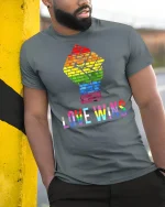 Love Wins Rainbow T-Shirt - model leaning on yellow-black pole, wearing Gray T-shirt, hand in pocket