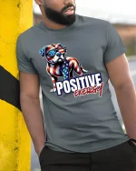 Positive Energy T-Shirt - American Flag Dog - model leaning on yellow-black pole, wearing Gray T-shirt, hand in pocket