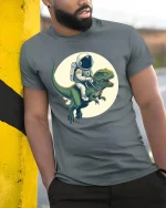 Space Explorer Dino Ride Tee - Funny Astronaut T-Shirt - model wearing grey tee, leaning on column