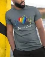 Love Is Love Rainbow Heartbeat Equality Pride T-Shirt - model wearing grey tee, leaning on column