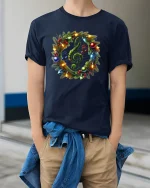 Christmas Music Wreath Treble Clef Holiday Lights Graphic Tee - model wearing navy tee with hands in pockets