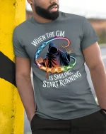 When the GM Is Smiling Funny RPG Gamer Tee - model wearing grey tee, leaning on column