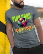 Play Hard Drip Hard Soccer Graphic T Shirt With Neon Street Art - model wearing grey tee, leaning on column
