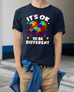 Its Ok To Be Different Colorful Puzzle Heart Graphic Tee - model wearing navy tee with hands in pockets
