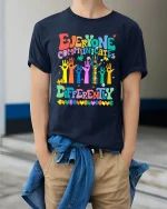 Everyone Communicates Differently Colorful Puzzle Graphic Tee - model wearing navy tee with hands in pockets