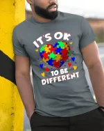 Its Ok To Be Different Colorful Puzzle Heart Graphic Tee - model wearing grey tee, leaning on column