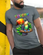 Colorful Toucan Tee with Tropical Cartoon Bird Jungle Artwork - model wearing grey tee, leaning on column