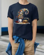 Whimsical Treasure Gnome Graphic Tee With Ocean Shell Fantasy Art - model wearing navy tee with hands in pockets