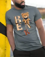 Cute Bear Letter Tee With Playful Cartoon Style Art - model wearing grey tee, leaning on column