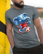 Cute Soccer Elephant Playing Football Cartoon Graphic T Shirt - model wearing grey tee, leaning on column