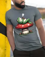 Chill Frog Smoking on Mushroom Funny Graphic T Shirt Vibes - model wearing grey tee, leaning on column