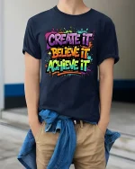 Create Believe Achieve Motivational Color Splash Graphic T-Shirt - model wearing navy tee with hands in pockets