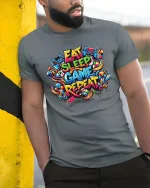 Eat Sleep Game Repeat Colorful Gamer Street Style Tshirt - model wearing grey tee, leaning on column