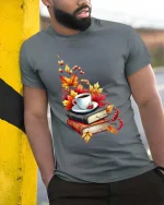 Cozy Autumn Coffee Books Graphic T-Shirt Fall Reading Tee - model wearing grey tee, leaning on column