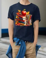 Autumn Books Apple Teacher Classroom Art Style tshirt - model wearing navy tee with hands in pockets
